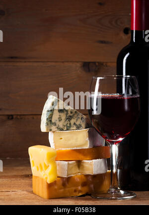 Rotwein mit verschiedenen Sorten Käse auf hölzernen Hintergrund Stockfoto