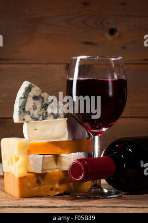 Rotwein mit verschiedenen Sorten Käse auf hölzernen Hintergrund Stockfoto