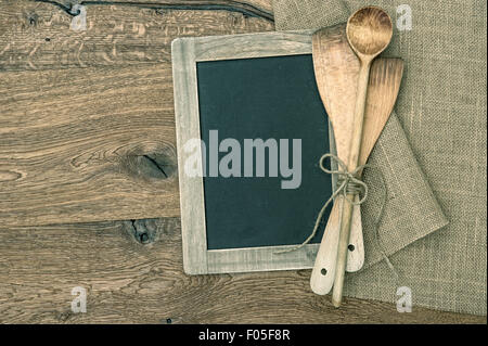 Alten Küchenutensilien und Vintage Tafel auf rustikalen hölzernen Hintergrund. Retro-Stil getönten Bild Stockfoto