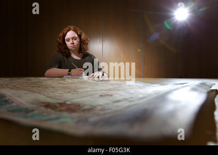 weibliche Archäologie studiert alte Karten Stockfoto