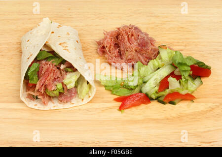 Wir fuhren Schweinefleisch Brot-Wrap mit Zutaten auf einem Holzbrett Stockfoto