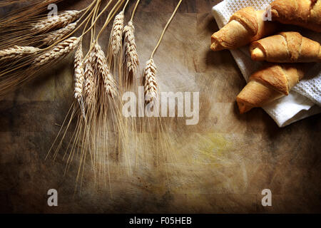 Frische Croissants und Weizen auf rustikalen Holztisch Stockfoto