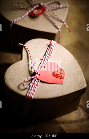Geschenk-Boxen mit handgefertigten Herzen Stichwörter auf Holzbrett Stockfoto