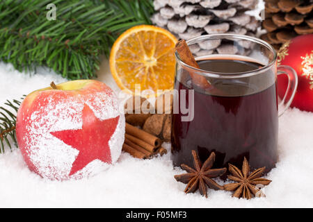 Winter-Apfelfrucht und Glühwein Wein Alkohol trinken auf Weihnachts-Dekoration mit Schnee Stockfoto