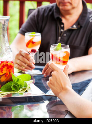 Paar weiße Sangria trinken. Weiße Sangria mit Früchten und Beeren. Stockfoto