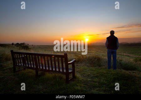 Southport, Merseyside, Großbritannien, 8. August 2015. Wetter in Großbritannien. 10 Grad Celsius mit niedrig liegendem Nebel bei Sonnenaufgang. RSPB Nature Reserve, Rimmer's Marsh mit kalter, feuchter Luft über Feuchtgebieten, verursacht durch eine atmosphärische Umkehrung - ein nebliger Zustand, in dem eine Schicht kühler Luft Bodennebel bildet. Dieses Gebiet, Teil der international wichtigen Ribble Mündung, ist eine reizvolle Balance von Wiese & Feuchtgebiete, die einen perfekten Lebensraum für Sommer Weiden & Feuchtgebiete Vögel und wichtige Zuflucht im Winter für rosa-footed Gänse und andere Wildvögel bieten. Stockfoto