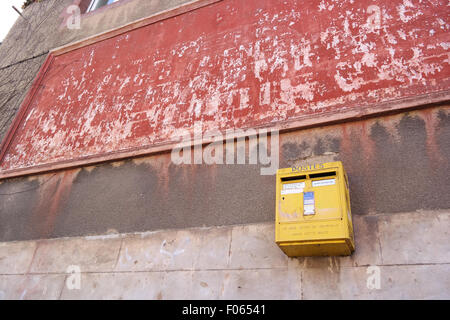 Alte gelbe französischer Briefkasten hängt an einer Wand in der Bretagne, Frankreich. Stockfoto