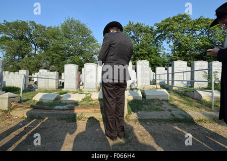 Einen religiösen jüdischen Mann Trauer über den Tod seiner Mutter am Montefiore Friedhof in Cambria Heights, Queens, New York Stockfoto