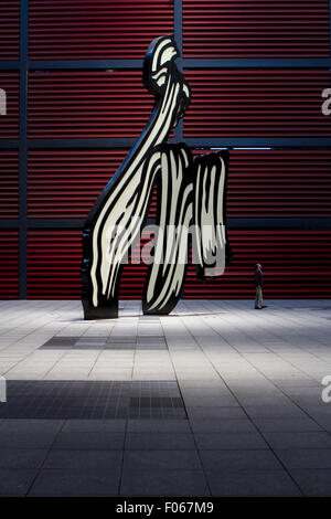 Ein Mann geht durch die Skulptur Pinselstrich von Roy Lichtenstein im Gericht von Reina Sofia Museum in Madrid, Spanien. Stockfoto