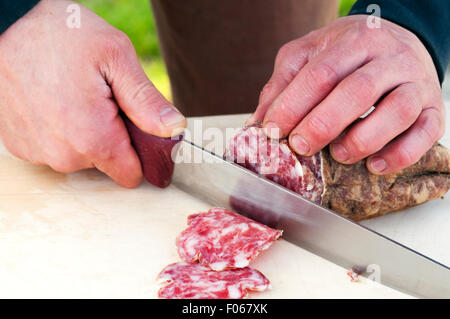 Italien, Lombardei, Cremona, Salami mit Stahl Messer, das schneidet Stockfoto