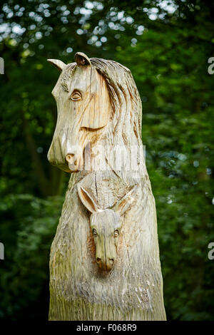 Woodbank Memorial Park in Offerton, Stockport, UK.   Starb ein Radfahrer vorbei an dem großen Baum Schnitzen in Erinnerung an die Tiere, die Stockfoto