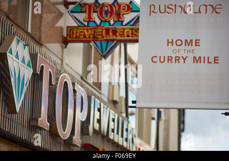 Rusholme A34 curry Mile in Manchester Uk erste 42 Buslinie Radfahren auf Straße Fahrrad Radfahrer Shop shopping Shopper Shop Einzelhandel s Stockfoto