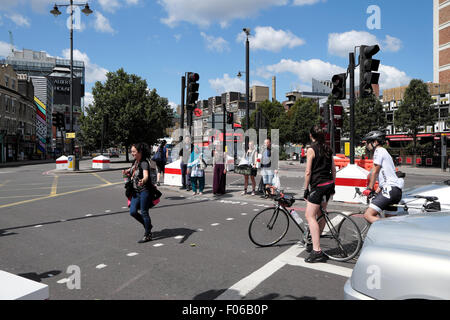 Eine weibliche Radfahrer wartet an der Ampel für Fußgänger auf einer Straßenkreuzung in Old Street, East London UK KATHY DEWITT Stockfoto