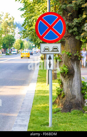 Warnschild Tow away Zone in der Nähe eines Baumes Stockfoto