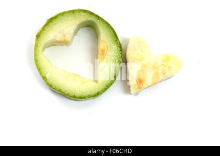 das Herz ist auf einem weißen Hintergrund aus eine Gurke geschnitten. Stockfoto