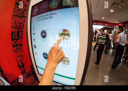 American Diner Bestellung an einem Kiosk "Erstellen Sie Ihren Geschmack" bei McDonalds am Dienstag, 4. August 2015 in New York. Die interaktive iPad-ähnliche Digitalanzeigen erlauben es Kunden, ihren Auftrag mit Belag, neue Soßen usw. anpassen und haben sie in wenigen Minuten an ihrem Tisch geliefert. McDonald's, die same-Store-Umsatzrückgang innerhalb von drei Jahren gesehen hat, nutzt die Kioske mit fast-casual Restaurants wie Chipotle, Fatburger und eine Vielzahl von anderen zu konkurrieren. (© Richard B. Levine) Stockfoto