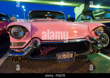 Bellmore, New York, USA. 7. August 2015. Eine 1957 pink Cadillac, mit einer Front grill Cadillac Abzeichen, ist auf in der Nähe der Hochbahn-Spuren auf der Freitag Nacht Auto Show statt in Bellmore Long Island Railroad Station Parkplatz geparkt. Hunderte von klassischen, antiken und kundenspezifische Autos wurden in die kostenlose wöchentliche Show, gesponsert von der Handelskammer von der Bellmores zu sehen. Stockfoto