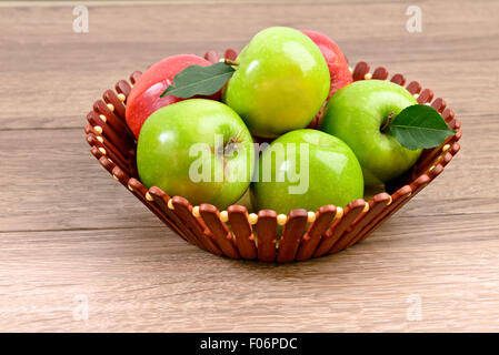 Äpfel im Korb auf braunem Holz Hintergrund Stockfoto