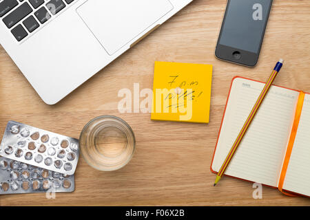 Laptop, Handy, Pillen und Glas Wasser Stockfoto