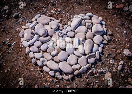 Herzförmige Design aus Kieselsteine am Strand Stockfoto