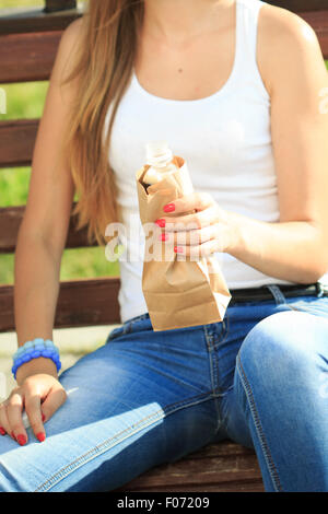 Mädchen mit einer Kunststoff-Flasche in eine Papiertüte Stockfoto