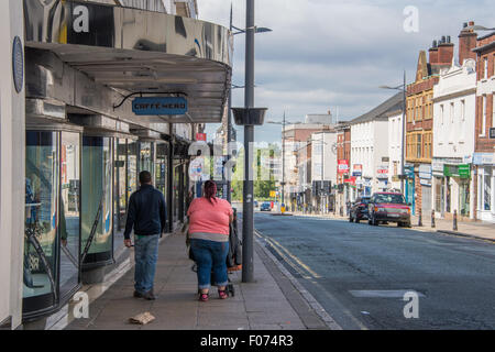 Ein paar mit einem Buggy walking Street in Wolverhampton West Midlands, uk Stockfoto