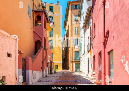 Schmale Straße zwischen alten bunten Häusern in Menton, Frankreich. Stockfoto