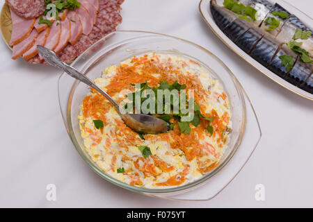 leckere herzhafte Salatplatte befindet sich auf dem Tisch neben den Hauptgerichten Stockfoto