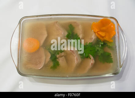gekochte Fleischstücke und Zunge in Aspik dekoriert mit Karotten Stockfoto