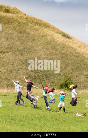 Avebury, Wiltshire, UK. 9. August 2015. Touristen genießen das Wetter als warme sonnige Bedingungen weiterhin Silbury Hill neolithischen Baudenkmal in die weiten offenen Ebenen des Wiltshire zu backen. Bildnachweis: Wayne Farrell/Alamy Live-Nachrichten Stockfoto