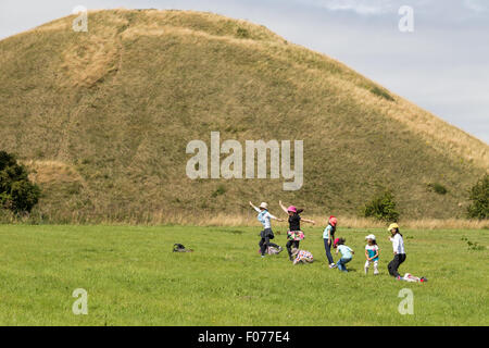 Avebury, Wiltshire, UK. 9. August 2015. Touristen genießen das Wetter als warme sonnige Bedingungen weiterhin Silbury Hill neolithischen Baudenkmal in die weiten offenen Ebenen des Wiltshire zu backen. Bildnachweis: Wayne Farrell/Alamy Live-Nachrichten Stockfoto