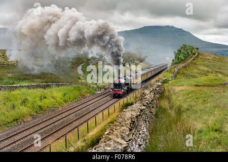 Mit Ingleborough Spitze als Kulisse leitet die Waverley Dampf besonderen Gefälle in Richtung Blea Moor Tunnel über Ribblehead-Viadukt an der Bahnstrecke Settle-Carlisle, North Yorkshire, UK, 9. August 2015. Stockfoto