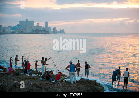 Havanna, Kuba - Mai 2011: Malerische Sonnenuntergang Silhouetten der Kubaner stehen Angeln auf den Felsen in der Nähe der beliebten Malecon. Stockfoto