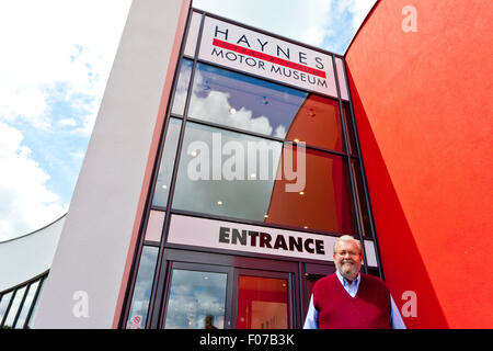 John Haynes Gründer der Haynes International Motor Museum, Sparkford, Somerset, England am imposanten neuen Eingang. Stockfoto