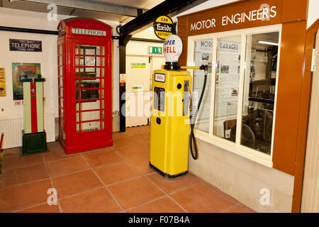 Ein rotes Telefon Box und Benzin Pumpe aus einer vergangenen Ära in Haynes International Motor Museum, Sparkford, Somerset, England, UK. Stockfoto