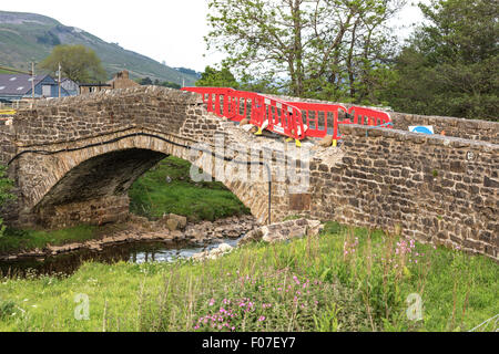 Schäden am Fahrzeug zu einer historischen Brücke im Swaledale, Yorkshire Dales National Park, England, UK Stockfoto