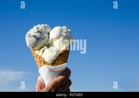 Hand hält ein Eis bei blauem Himmel Stockfoto