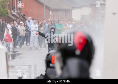 Belfast, Nordirland. 9. August 2015 - wirft nationalistischen Jugend einen Stein nach PSNI Offiziere während besprüht von einem Wasserwerfer nach einer Anti-Internierung-Rallye. Bildnachweis: Stephen Barnes/Alamy Live-Nachrichten Stockfoto