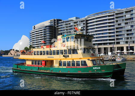 Sydney Fähren Sirius nähert sich Circular Quay Fähranleger Waterfront-Gebäude und das Opernhaus im Hintergrund. Stockfoto