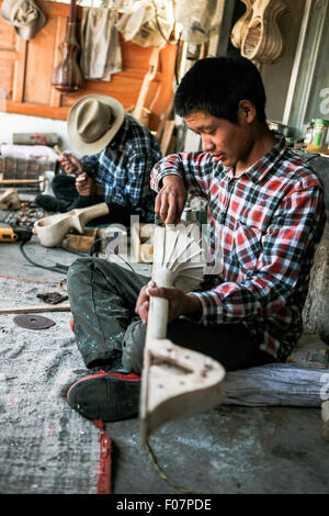 (150810)--LHASA, 10. August 2015 (Xinhua)--46-j hrige Handwerker Dainzin (hinten) und seinem Sohn machen tibetische Instrument Dramyin in Lhasa, der Hauptstadt von Südwesten Chinas Tibet autonome Region, 9. August 2015. Dramyin, ein 6-saitige Instrument spielt, ist eine alte tibetische gerupft Instrumente. Es ist ein lang-necked, Doppel-taillierte und fretless Laute. Es ist in der Regel aus einem einzigen Stück Holz ausgehöhlt und in der Größe von 60 bis 120 Zentimeter in der Länge variieren kann. Im Jahr 2014 hat die Herstellung von Draymin als einer von Chinas nationale immaterielle Kulturerbe eingetragen worden. (Xinhua/Zheng Huansong) (Zhs/Lfj) Stockfoto