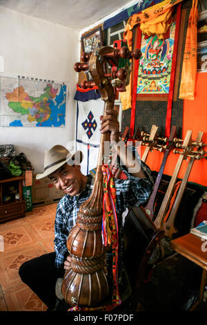 (150810)--LHASA, 10. August 2015 (Xinhua)--46-j hrige Handwerker Dainzin zeigt einen tibetischen Instrument Dramyin in Lhasa, der Hauptstadt der Südwesten Chinas Tibet autonome Region, 9. August 2015. Dramyin, ein 6-saitige Instrument spielt, ist eine alte tibetische gerupft Instrumente. Es ist ein lang-necked, Doppel-taillierte und fretless Laute. Es ist in der Regel aus einem einzigen Stück Holz ausgehöhlt und in der Größe von 60 bis 120 Zentimeter in der Länge variieren kann. Im Jahr 2014 hat die Herstellung von Draymin als einer von Chinas nationale immaterielle Kulturerbe eingetragen worden. (Xinhua/Zheng Huansong) (Zhs/Lfj) Stockfoto