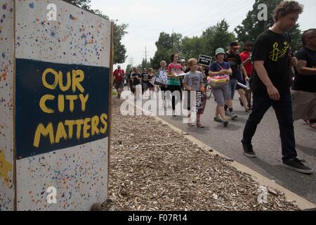 Ferguson, Missouri, USA. 9. August 2015. Menschen marschieren durch ein Schild in Ferguson, Missouri, USA, am 9. August 2015. Mehrere hundert Menschen haben am Sonntag zum Jubiläum von die Todesschüsse auf den unbewaffneten schwarzen Teenager von einem weißen Polizisten, die Proteste und eine nationale Debatte über Rennen und Gerechtigkeit löste in Ferguson. (Xinhua/Marcus DiPaola) Bildnachweis: Xinhua/Alamy Live-Nachrichten Stockfoto