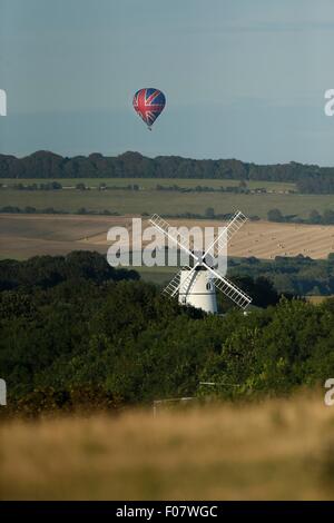 Ein Heißluftballon zieht über Waterhall Mill in Patcham nördlich von Brighton, wie die späte Nachmittagssonne beginnt zu gründen. Stockfoto