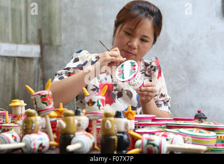 Linyi, Shandong Provinz. 9. August 2015. Dorfbewohner Yang Lan macht hölzerne Spinnen Spielzeug in Fannian Dorf Tancheng County, der ostchinesischen Provinz Shandong, 9. August 2015. Hölzerne Spinnen Spielzeug, stammt aus der südlichen Shandong hat als eines der nationalen immateriellen Kulturerbe in 2014 aufgelistet. © Zhang Chunlei/Xinhua/Alamy Live-Nachrichten Stockfoto