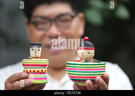 Linyi, Shandong Provinz. 9. August 2015. Erben Fan Jimei zeigt Spielzeug aus Holz Spinnerei in Tancheng County, Ost-China Shandong Provinz, 9. August 2015. Hölzerne Spinnen Spielzeug, stammt aus der südlichen Shandong hat als eines der nationalen immateriellen Kulturerbe in 2014 aufgelistet. © Zhang Chunlei/Xinhua/Alamy Live-Nachrichten Stockfoto