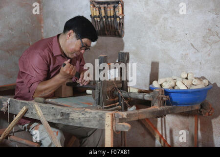 Linyi, Shandong Provinz. 9. August 2015. Erbe-Fan Jimei macht hölzerne Spinnen Spielzeug in Tancheng County, Ost-China Shandong Provinz, 9. August 2015. Hölzerne Spinnen Spielzeug, stammt aus der südlichen Shandong hat als eines der nationalen immateriellen Kulturerbe in 2014 aufgelistet. © Zhang Chunlei/Xinhua/Alamy Live-Nachrichten Stockfoto