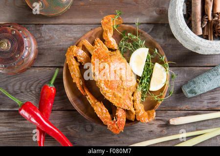 Ansicht von oben gekocht heiß und würzig Soße blaue Krabbe und Zutaten, auf hölzernen Hintergrund. Frisch kochen mit heißem Rauch dampft. Stockfoto