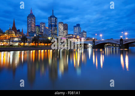 Die Skyline von Melbourne, Australien mit Flinders Street Station und die Prinzen-Brücke aus über den Yarra River in der Nacht. Stockfoto