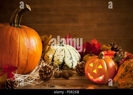 Rustikale Herbst Stilleben mit Kürbissen und ein Jack O'Lantern auf einem Holztisch. Stockfoto