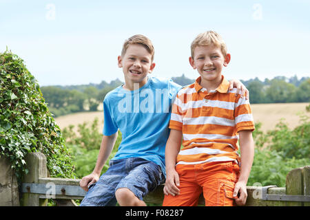 Porträt von zwei jungen Zusammensitzen auf Tor Stockfoto